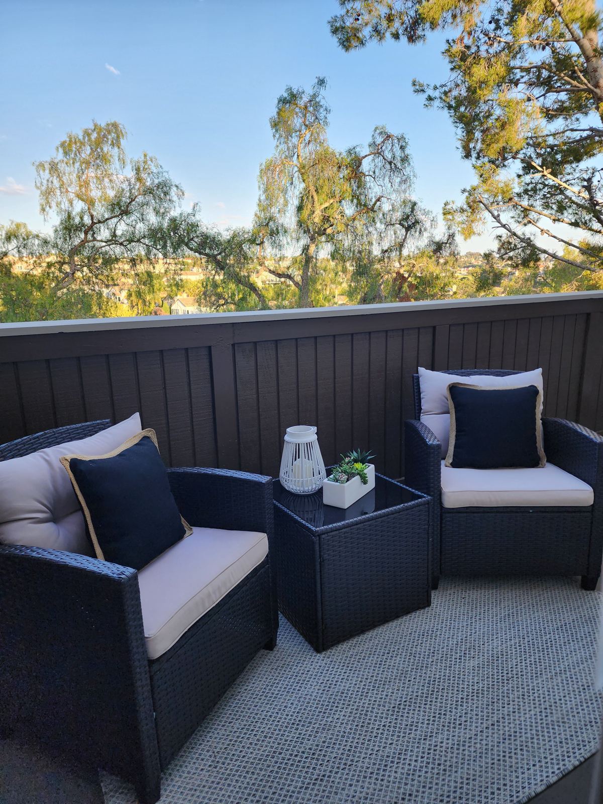 Staged balcony lounge seating with treetop views — Laguna Woods home staging